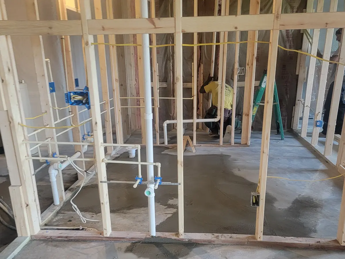 remodeling basement process, worker installing wood frames and pipes
