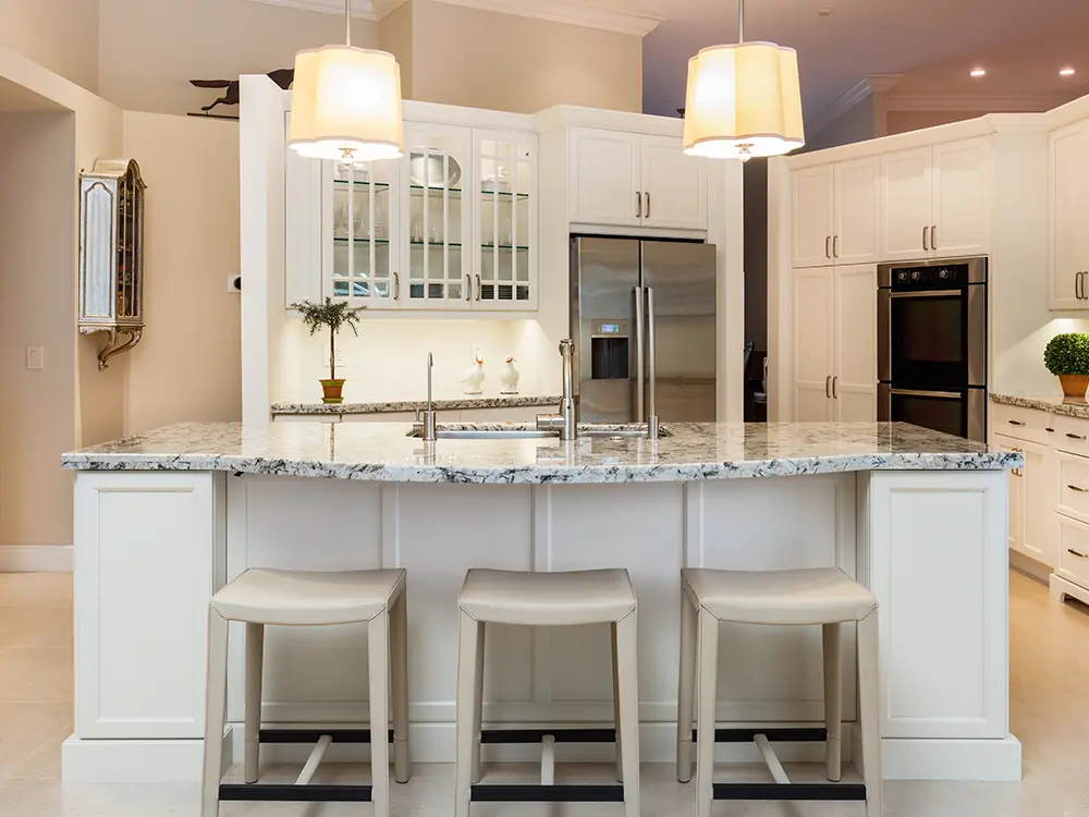 oepn kitchen with kitchen island bar, white cabinets and white and black pattern countertops