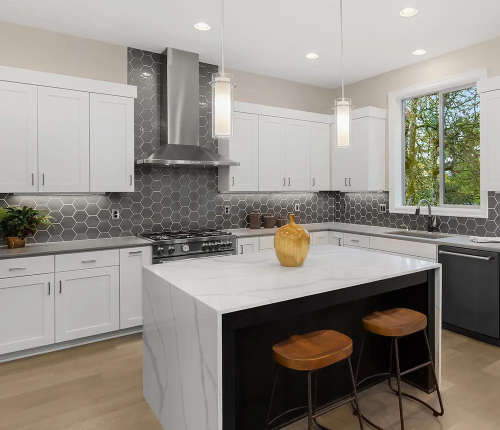 modern kitchen with kitchen island, white cabinets, gray countertops and black and white pattern on the walls